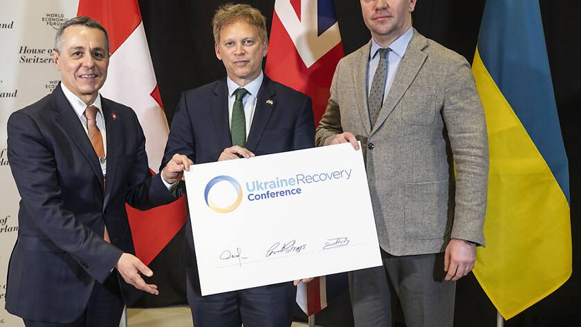 Bundesrat Ignazio Cassis hat am Mittwoch in Davos dem britischen Staatssekretär, Grant Shapps (Mitte) in Anwesenheit des ukrainischen Staatssekretärs Oleksandr Bankov (rechts) symbolisch die Aufgabe für die nächste Ukraine-Wiederaufbau-Konferenz übertragen.