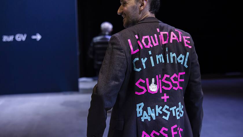 Ein Mann trägt einen "Liquidate Criminal Suisse + Banksters Assets" während der CS-Generalversammlung Anfang April. Der Kollaps der Grossbank hat das Vetrauen in die Schweizer Wirtschaft einbrechen lassen.