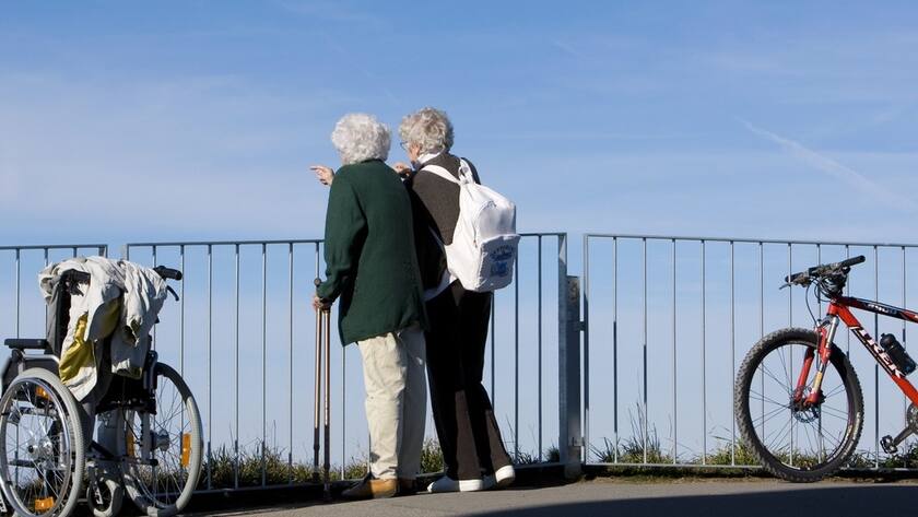 Zwei Seniorinnen stehen zwischen einem Rollstuhl und einem Mountainbike und geniessen die Aussicht ab der Rigi, am Samstag, 3. Oktober 2009. (KEYSTONE/Alessandro Della Bella)
