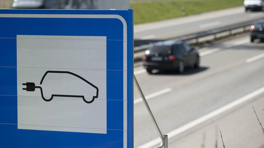 Eine Tafel auf einem Rastplatz auf der A1 weist auf die Fastned-Elektroauto-Schnellladedestination hin.