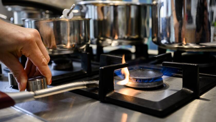 Une personne allume le gaz pour chauffer des casseroles d'une cuisine dans une habitation familiale le samedi 3 septembre 2022 a Yverdon. La Suisse devrait diminuer sa consommation de gaz de 15%. Le Conseil federal s'est fixe un objectif volontaire de reduction pour le semestre d'hiver. (KEYSTONE/Jean-Christophe Bott)