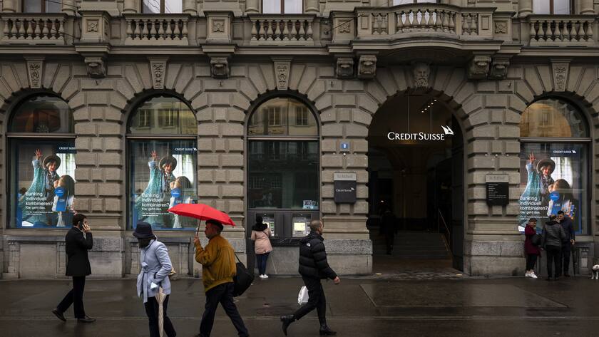 People walk past the headquarters of the Swiss bank Credit Suisse at Paradeplatz in Zurich, Switzerland, on Friday, March 24, 2023. (KEYSTONE/Michael Buholzer).
