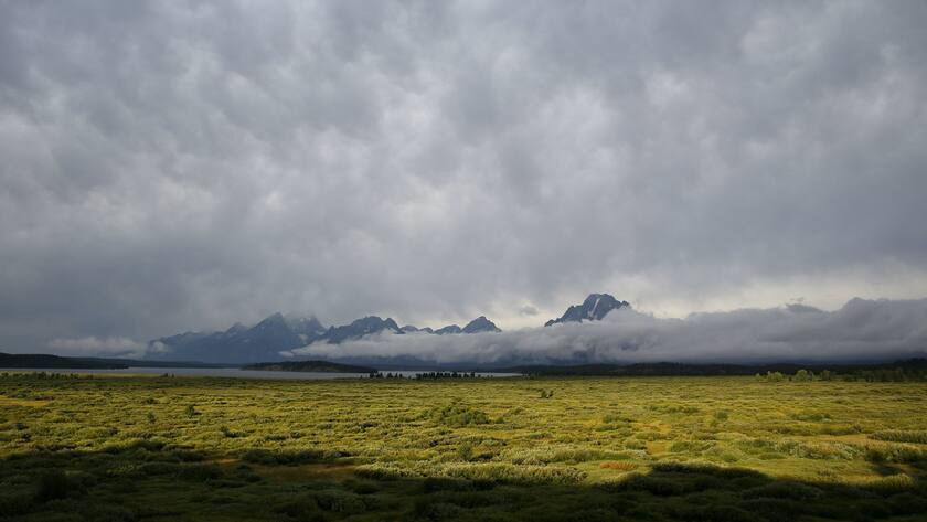 Clouds engulf the Teton mountain range near the Jackson Lake Lodge Friday, Aug. 22, 2014, near Jackson, Wyo. The Federal Reserve Bank of Kansas City is holding the Jackson Hole Economic Policy Symposium at the lodge. (AP Photo/John Locher)