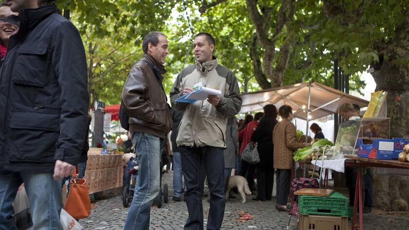 Passantinnen und Passanten unterschreiben am 24. Oktober 2009 an einem Stand der Lungenliga Aargau am Gemuesemarkt in Aaarau, Schweiz, die Volksinitative "Schutz vor Passivrauchen". (KEYSTONE/Martin Ruetschi)