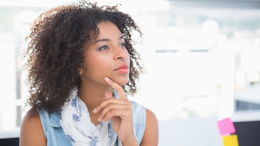 Pretty designer thinking at her desk in her office