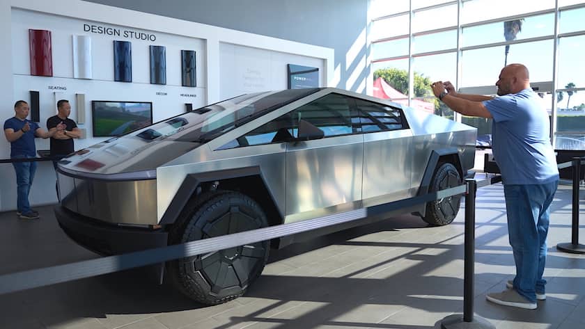 epa11006474 People view and take pictures of a Tesla Cybertruck on display at Tesla in Buena Park, California, USA, 01 December 2023. After four years of delays and complications, the Tesla Cybertruck was released on 01 December by Tesla CEO Elon Musk. The cheapest rear-wheel drive model won't be available until 2025 at the earliest, with a price starting at 60,990 US dollars. EPA/ALLISON DINNER