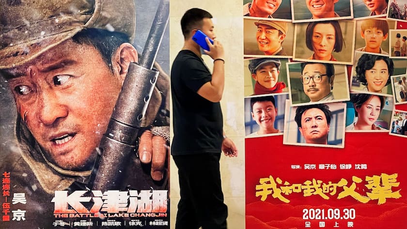 BEIJING, CHINA - SEPTEMBER 30: A man walks by posters of films 'My Country, My Parents' and 'The Battle at Lake Changjin' at a cinema ahead of China's National Day on September 30, 2021 in Beijing, China. (Photo by VCG/VCG via Getty Images)