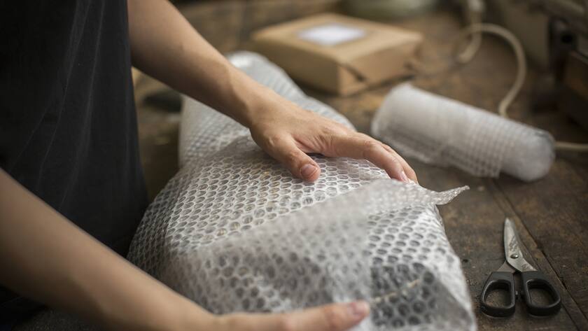 A woman wrapping an item in bubble wrap, a parcel being prepared for despatch. (KEYSTONE/Mint Images/Mint Images)