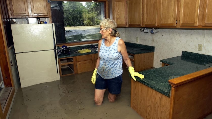 Joan Wissmiller, 67, blickt durch ihre überflutete Küche und versucht, so viel wie möglich zu retten, während das Hochwasser des Guadalupe River am Samstag, dem 6. Juli 2002, in Seguin, Texas, vor ihrem Fenster und durch ihr Haus strömt.