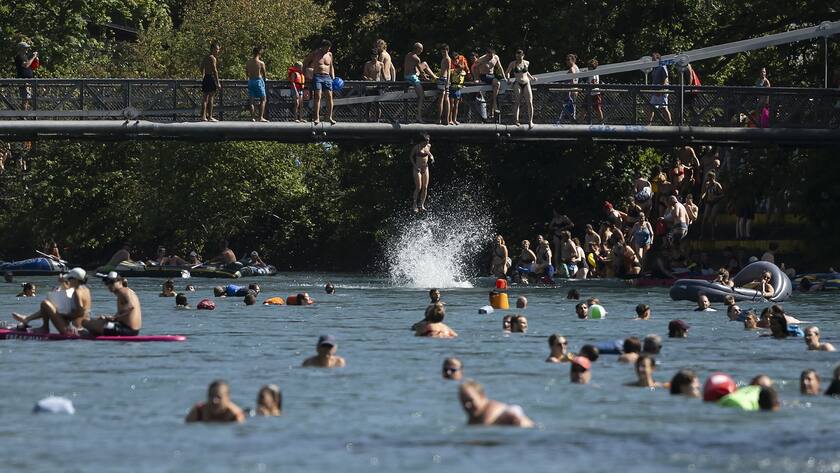 Eine Frau springt von der Schonausteg-Brücke in die Aare bei sonnigem und warmem Wetter in Bern, Schweiz, Sonntag, 20. August 2023.