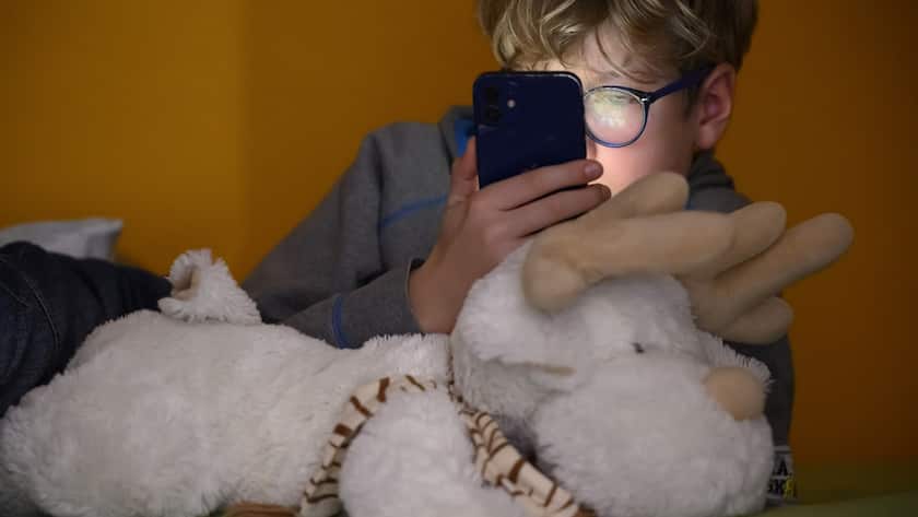 Ein 10-jähriges Kind betrachtet am Mittwoch, dem 4. Dezember 2024, in Lausanne ein Apple iPhone Smartphone.