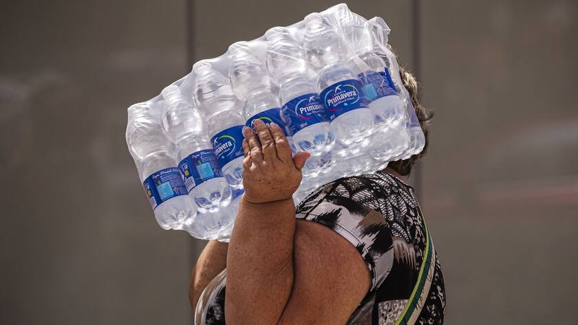 A woman carries water bottles along Malagueta beach in Malaga, Spain on 19 July 2023.
