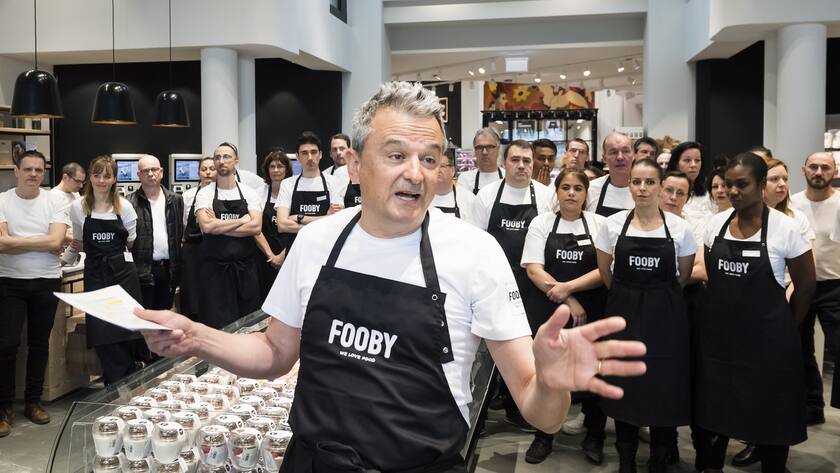 Joos Sutter, Präsident des Coop-Verwaltungsrats, spricht in Fooby-Schürze an einer Presskonferenz über das neue Fooby-Format.