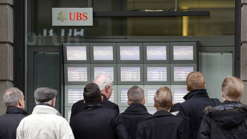 Menschen verfolgen die Entwicklung der Kurse an der Zuercher Banhhofstrasse nach den Turbulenzen an der Boerse nach der Aufhebung des Euromindestkurses durch die Schweizerische Nationalbank in Zuerich am Donnerstag,