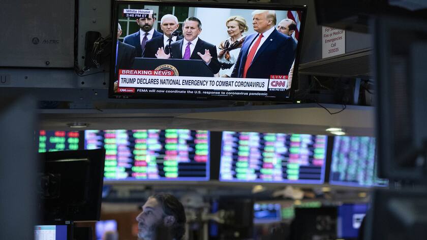 A trader listens from the New York Stock Exchange to President Donald Trump's televised speech from the White House, Friday, March 13, 2020. President Trump declared the coronavirus pandemic a national emergency, as Washington struggles with providing Americans with relief and officials race to slow the spread of the outbreak. (AP Photo/Mark Lennihan)