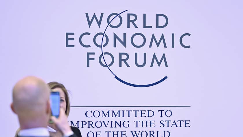 A man takes a picture of a woman in front of the WEF logo on the closing day of the 53rd annual meeting of the World Economic Forum, WEF, in Davos, Switzerland, Friday, January 20, 2023. The meeting brings together entrepreneurs, scientists, corporate and political leaders in Davos under the topic "Cooperation in a Fragmented World" from 16 to 20 January. (KEYSTONE/Gian Ehrenzeller)