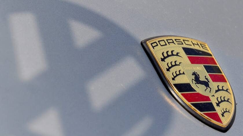 epa03296176 A Porsche budge appears in the shadow of the Volkswagen logo in Stuttgart, 5 July 2012. Volkswagen is set to take complete control of Porsche, VW announced on 04 July 2012 from its headquarters in Wolfsburg, Germany. Sports car maker Porsche is due to come under VW's control control by 01 August 2012. EPA/FRANZISKA KAUFMANN