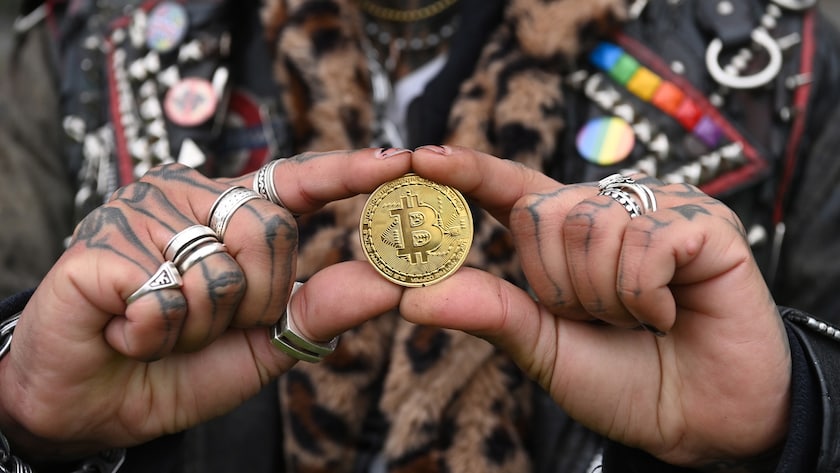 epa09600698 A performer holds a metal representation of a Bitcoin during a photocall in front of the Tower of London in London, Britain, 24 November 2021. The photocall was organized to celebrate the 8th anniversary of the crypto exchange Huobi Global. EPA/FACUNDO ARRIZABALAGA