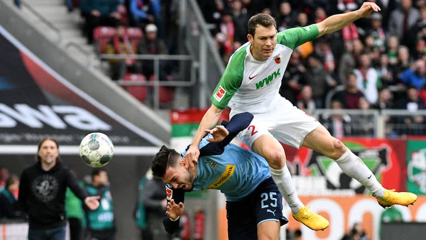 Bundesliga, FC Augsburg - Borussia Mönchengladbach, 24. Spieltag in der WWK-Arena. Augsburgs Stephan Lichtsteiner (r) und Mönchengladbachs Ramy Bensebaini kämpfen um den Ball.