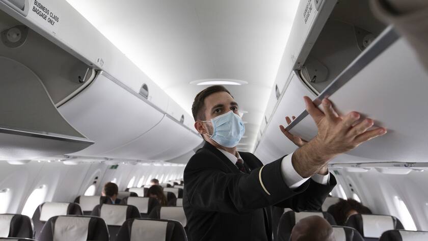 Die Swiss führt eine Impfpflicht für die Crew ein A cabin crew member of Swiss International Air Lines wearing a face mask to protect against the spread of coronavirus COVID-19 prepares the aircraft prior to departure to London during the resumption partially flights of Swiss International Air Lines following the lockdown to due lockdown measures against spread of coronavirus COVID-19, at the Geneve Aeroport, in Geneva, Switzerland, Monday, June 15, 2020. (KEYSTONE/Salvatore Di Nolfi)
