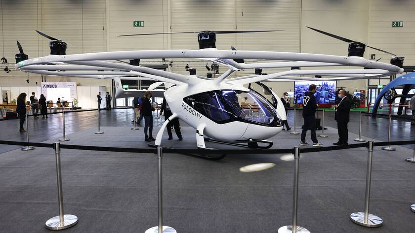 ARCHIV - 16.11.2021, Nordrhein-Westfalen, Köln: Das elektrische Lufttaxi Volocopter des Herstellers Volocity steht in der Messehalle. Die dreitägige Messe «European Rotors» mit rund 150 Ausstellern hat begonnen. Der baden-württembergische Flugtaxi-Hersteller Volocopter soll für die neue Stadt Neom in Saudi-Arabien Fluggeräte liefern.(zu dpa "Volocopter soll Passagier- und Lastdrohnen für Saudi-Arabien liefern") Foto: Oliver Berg/dpa +++ dpa-Bildfunk +++ (KEYSTONE/DPA/Oliver Berg)