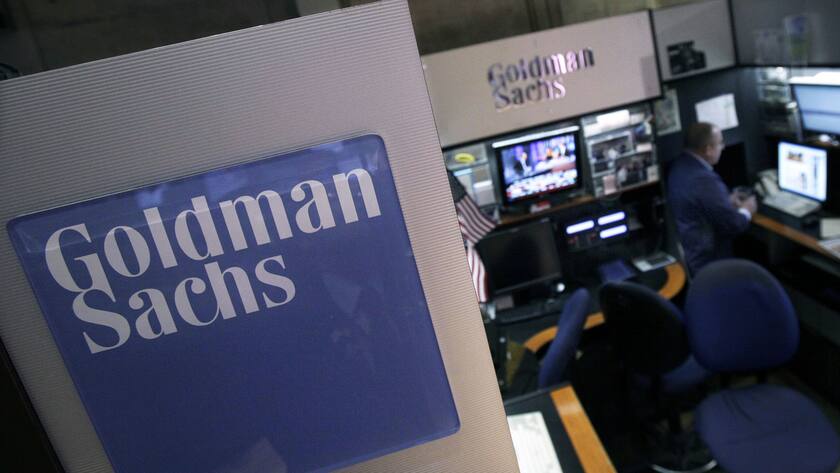 FILE - In this March 15, 2012 file photo, a trader works in the Goldman Sachs booth on the floor of the New York Stock Exchange. On Monday, Aug. 5, 2013, it was announced that the London Metal Exchange and Goldman Sachs are being sued in a U.S. court over alleged anti-competitive and monopolistic behavior in aluminum storage. (AP Photo/Richard Drew, File)