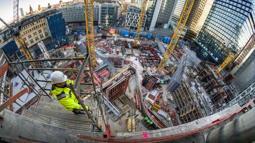21.12.2021, Hessen, Frankfurt/Main: Oberbauleiter Jens Schönberg (l) steht über einer der grössten innerstädtischen Baustellen Deutschlands. Zwischen Bankenviertel und Innenstadt entsteht hier das Projekt Four. Vier Türme wachsen langsam empor, der kleinste soll 100, der grösste 233 Meter hoch werden.