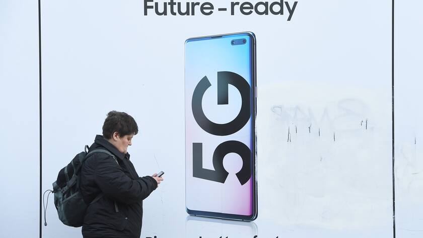 epa08176146 A pedestrian walks past an advert displaying a 5G sign in London, Britain, 29 January 2020. The Government has decided to let the Chinese company Huawei to continue to be used in its 5G networks but with restrictions. EPA/FACUNDO ARRIZABALAGA