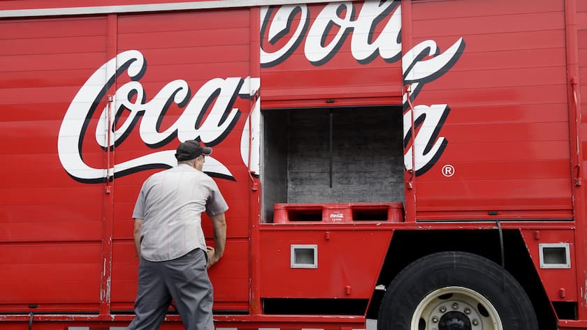 Ein Zusteller schliesst die Fächer eines Coca-Cola-Lkw.
