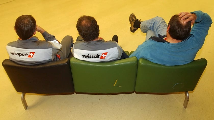 Des employes de la compagnie aerienne Swissair et de Swissport depriment lors de l'assemblee generale du personnel de Swissair Group ce lundi 3 decembre 2001 au terminal Charter de l'aeroprt de Geneve. Les employes de Swissair Group ont participe a un assemblee pour prendre connaissance des dernieres evolutions du plan social qui doit leur etre attribue. (KEYSTONE/Laurent Gillieron)