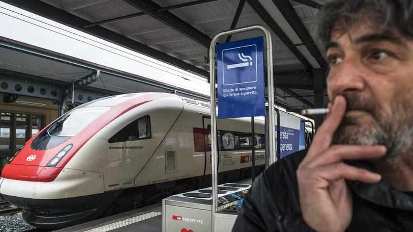 Ein Mann raucht seine Zigarette in einem der Raucher-Bereiche auf einem Perron, fotografiert am 1. Februar 2018 am Bahnhof Bellinzona. In verschiedenen Bahnhoefen der Schweiz ist das Rauchen ab heute nur noch in gewissen Bereichen erlaubt. (KEYSTONE/Ti-Press/Alessandro Crinari)