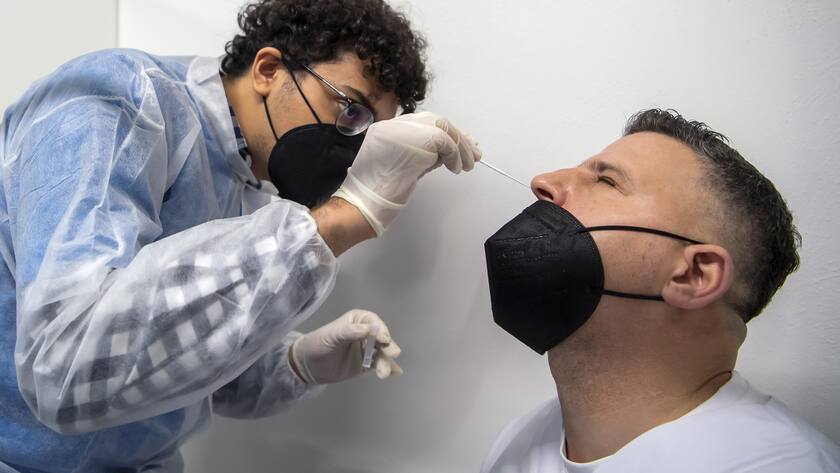 Un collaborateur de City Test, procede a un test de depistage du Coronavirus sur un patient dans le Nouveau Centre de depistages Covid-19, ce jeudi 30 decembre 2021 a Geneve. L'arrivee de City Test au centre-ville permettra de decharger les differentes structures de testing (centres, pharmaciesÖ) et de repondre a une demande en augmentation constante avec l'arrivee du variant Omicron a Geneve. Occupant deux etages, City Test realisera 1000 a 1500 depistages par jour. (KEYSTONE/Martial Trezzini)