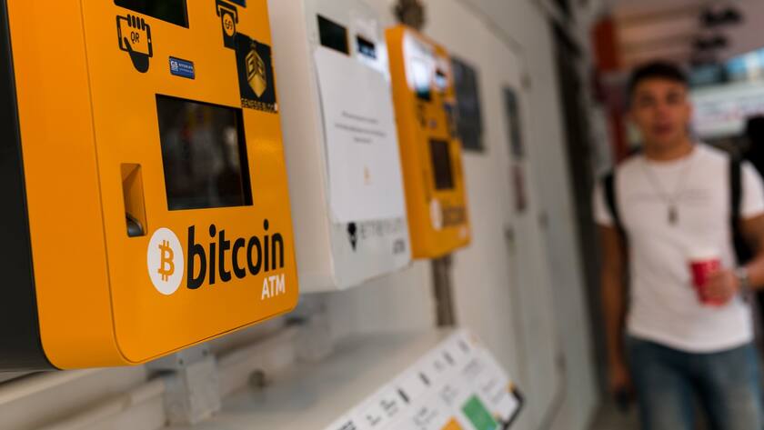 Ein Bitcoin ATM in Hong Kong, ein Mann läuft auf den ATM zu.