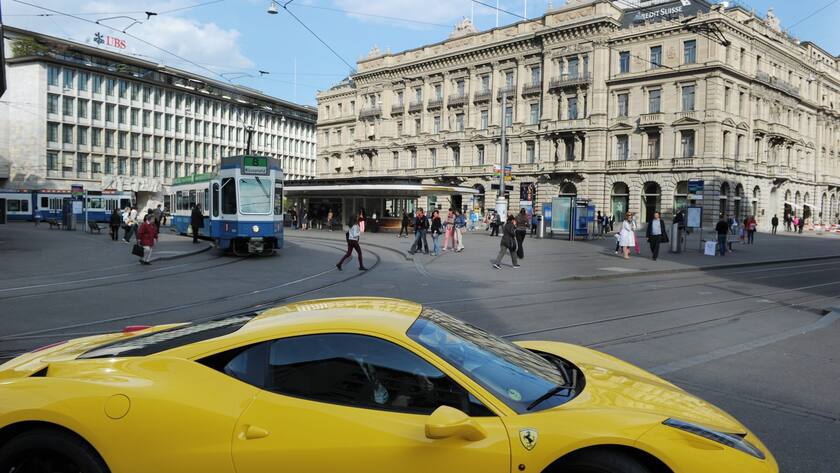 Ein exklusives Sportauto biegt vor den Fassaden der Grossbanken UBS, links, und Credit Suisse, rechts, in eine Strasse ein, am Donnerstag 18. April 2013, am Paradeplatz in Zuerich. (KEYSTONE/Steffen Schmidt)