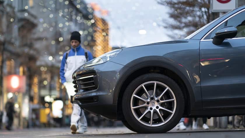 Ein grosses SUV-Auto der Marke Porsche faehrt auf der Bahnhostrasse vor einem Fussgaenger her, fotografiert am Freitag 26. November 2021 in Zuerich. (KEYSTONE/Gaetan Bally)