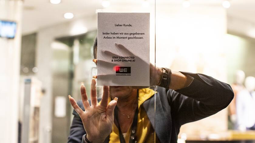 Eine Frau klebt eine Information an ein Schaufenster in einem Geschaeft an der Bahnhofstrasse in Zuerich am Montag, 16. Maerz 2020. Der Bundesrat hat den den nationalen Notstand erklärt. Ab Mitternacht sind öffentliche und private Veranstaltungen verboten. Alle Laeden, Maerkte, Restaurants, Bars sowie Unterhaltungs- und Freizeitbetriebe werden geschlossen. (KEYSTONE/Alexandra Wey)