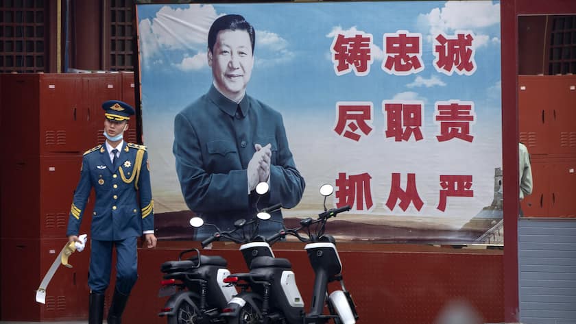 A Chinese honor guard member walks past a poster of Chinese leader Xi Jinping near the entrance to the Forbidden City in Beijing, Saturday, Sept. 18, 2021. (AP Photo/Mark Schiefelbein)