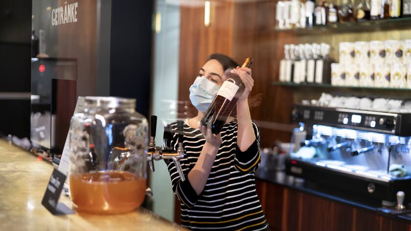 Eine Mitabreiterin des Kinos Houdini bedient an der Bar mit Schutzmaske einen Gast im Kino Houdini, fotografiert am Freitagabend, 13. November 2020, in Zuerich.