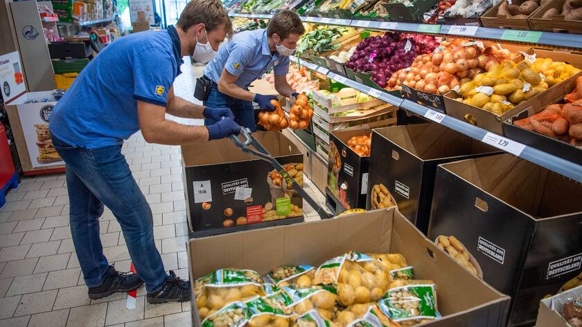 30.04.2020, Bayern, Brunnthal: Kevin Krawietz (l), Tennisprofi, räumt in einem Lidl-Discounter Kartoffeln neben dem Filialleiter Mirnis Terzic in ein Regal. Der French-Open Sieger hat durch die Turnier-Ausfälle wegen Corona in einem 450· Job angefangen. Foto: Lino Mirgeler/dpa +++ dpa-Bildfunk +++ (KEYSTONE/DPA/Lino Mirgeler)
