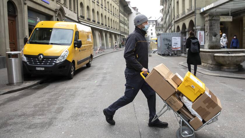 Die Post verschärft ihre Corona-Massnahmen Ein Paketbote der Post liefert Pakete aus, am Donnerstag, 11. Februar 2021, in Bern. (KEYSTONE/Peter Klaunzer)