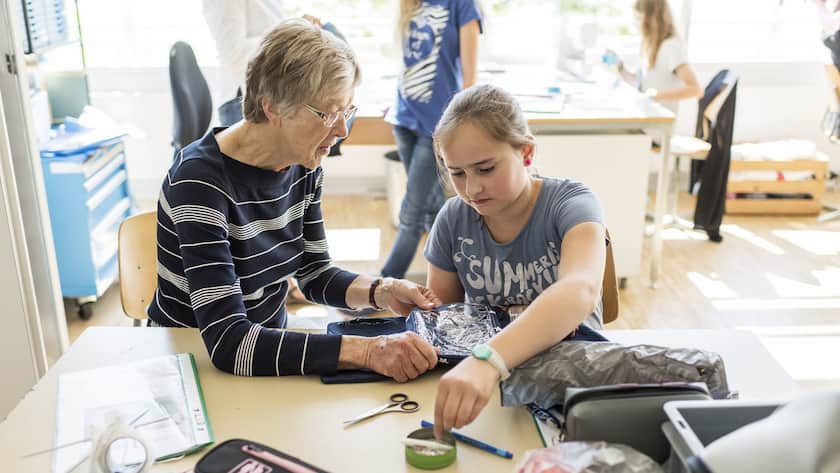 Eine Rentnerin hilft Primarschuelern freiwillig beim Textilunterricht, anlaesslich des Projektes win3, drei Generationen im Klassenzimmer, von Pro Senectute, in Schliern, am 24. Juni 2015. (KEYSTONE/Christian Beutler)