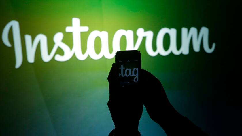 FILE - In this Thursday, June 20, 2013 file photo, a journalist makes a video of the Instagram logo using the new video feature at Facebook headquarters in Menlo Park, Calif. Instagram has removed an account that published comic strips depicting the struggles of gay Muslims in Indonesia following a frenzy of moral outrage online in the world's biggest Muslim nation. (AP Photo/Marcio Jose Sanchez, File)