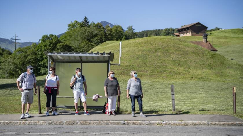 Eine Gruppe Wanderer wartet auf das Postauto bei der Haltestelle Sagendorf in Emmetten im Kanton Nidwalden.