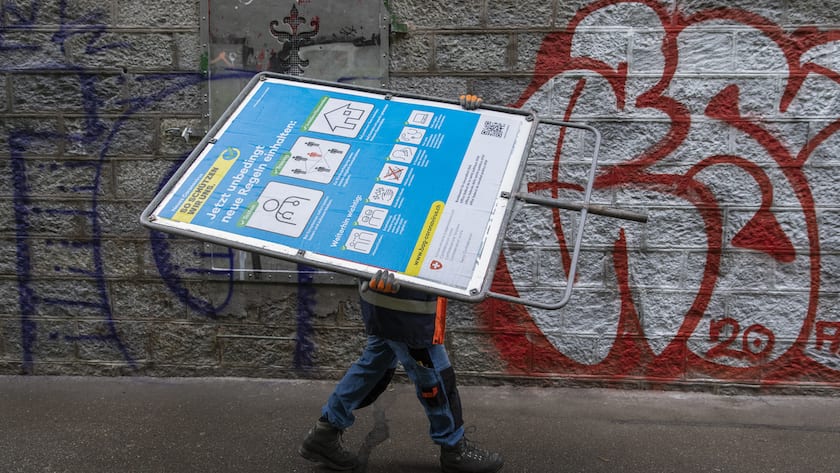 Roger Mundwiler, Mitarbeiter des Tiefbauamts der Stadt Bern, trägt ein neues blaues BAG-Plakat mit Verhaltensregeln im Umgang mit dem Coronavirus zu einem Standort an der Aare, am Mittwoch, 10. Juni 2020 in Bern.