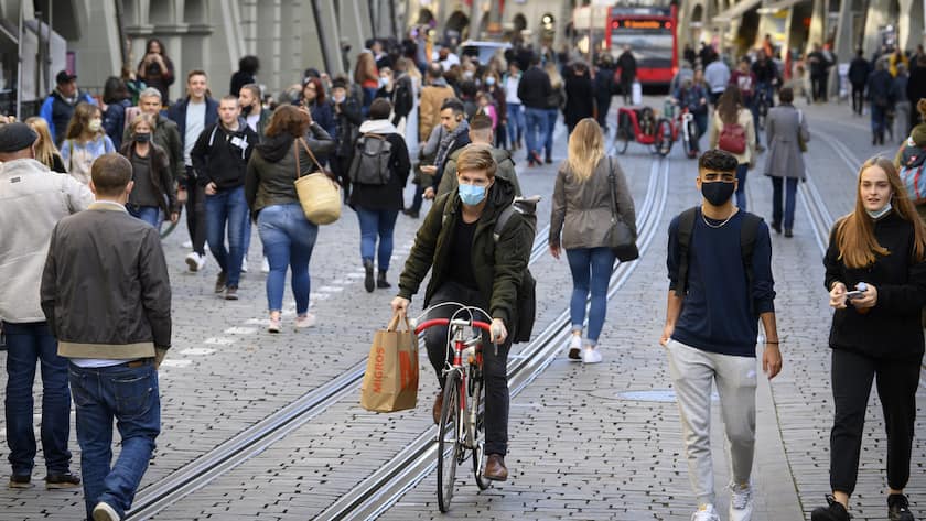 Personen mit und ohne Schutzmasken gehen durch die Marktgasse in Bern waehrend der Corona-Krise
