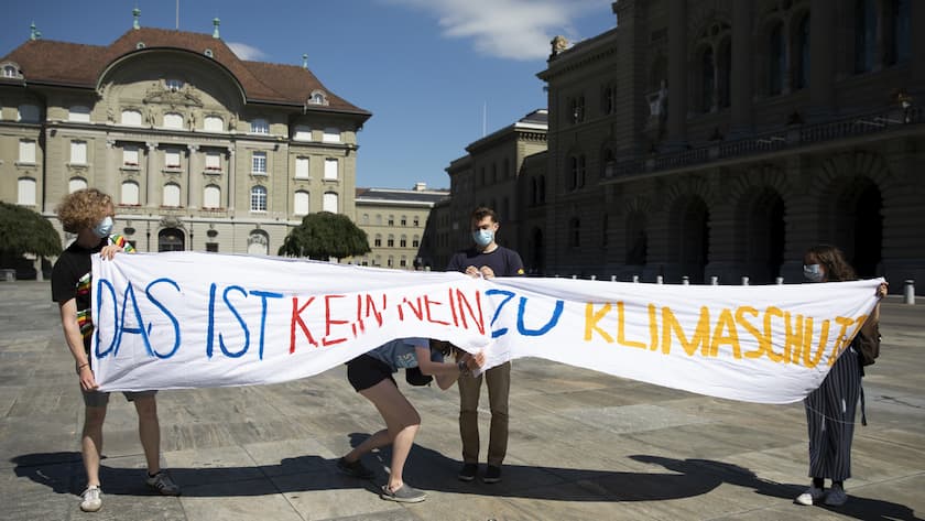 Mitglieder des Klimastreiks halten Banner hoch, vor einer kurzfristig anberaumten Medienkonferenz auf dem Bundesplatz, am Sonntag, 13. Juni 2021, in Bern. (KEYSTONE/Peter Klaunzer)