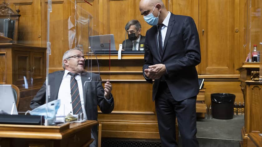 Bundesrat Alain Berset, rechts, diskutiert mit Benjamin Roduit, Mitte-VS, waehrend der Debatte um die BVG-Reform, waehrend der Wintersession der Eidgenoessischen Raete, am Dienstag, 7. Dezember 2021, im Nationalrat in Bern. (KEYSTONE/Peter Klaunzer)