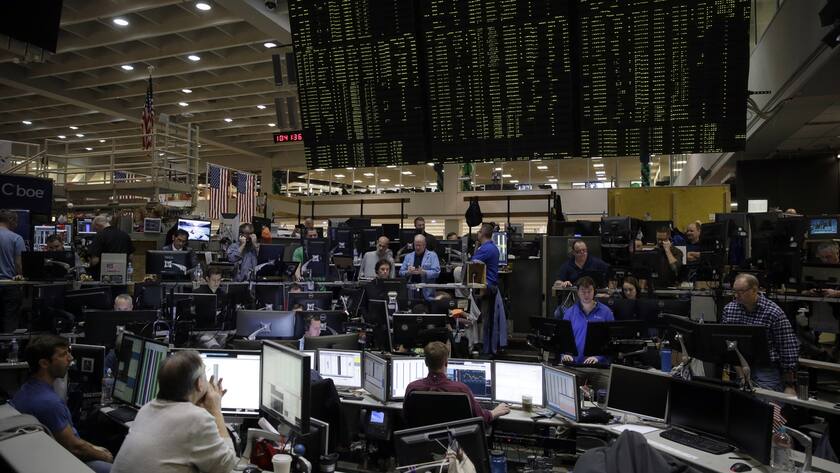 Traders work in a trading pit at the Chicago Board Options Exchange, Monday, Dec. 11, 2017, in Chicago, as they trade VIX products futures and options, unrelated to bitcoin futures. Trading in Bitcoin futures began Sunday on the CBOE. (AP Photo/Kiichiro Sato)