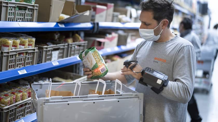 Ein Mitarbeiter stellt eine Kundenbestellung in einem Lager-, Logistik- und Distributionszentrum von Migros Online zusammen, fotografiert am 3. Juni 2021 in Pratteln, Kanton Basel-Landschaft. (KEYSTONE/Gaetan Bally)