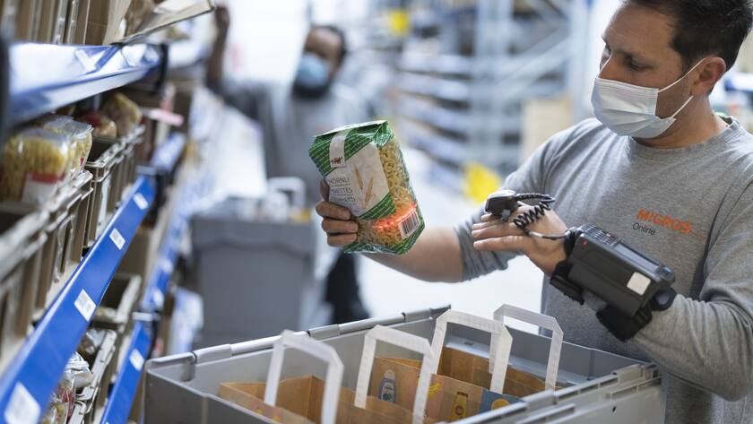 Ein Mitarbeiter stellt eine Kundenbestellung in einem Lager-, Logistik- und Distributionszentrum von Migros Online zusammen, fotografiert am 3. Juni 2021 in Pratteln, Kanton Basel-Landschaft. (KEYSTONE/Gaetan Bally)